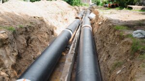 Plumbing repair. Installation of new industrial street water pipes in dug hole in two lines, outdoors